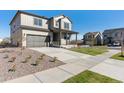 Attractive home exterior featuring a front porch, landscaped front yard with rocks, and a wide driveway at 9882 Cathay St, Commerce City, CO 80022