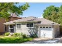 Charming single-story home showcasing mature trees and a well-maintained yard and an attached garage at 1627 S Saint Paul St, Denver, CO 80210