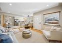 Bright open-concept living room featuring hardwood floors, neutral decor, and access to the kitchen at 1627 S Saint Paul St, Denver, CO 80210