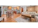 Open-concept living space with hardwood floors, a stone accent wall, and comfortable seating at 37653 Lark Dr, Elizabeth, CO 80107