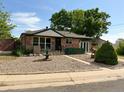 Quaint home features a manicured front yard, a fountain, and mature trees at 10440 Gilpin St, Northglenn, CO 80233