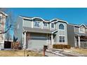 Two-story home with gray siding, attached two-car garage, and minimal front landscaping at 9649 Lansing Cir, Commerce City, CO 80022