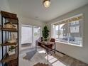 Well-lit home office featuring a modern desk, shelving, and a large window with neighborhood views at 13040 E 103Rd Ave, Commerce City, CO 80022
