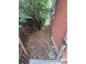 Narrow side yard with gravel, a wooden fence, and a brick house at 387 Tucson St, Aurora, CO 80011