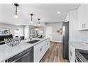 Modern kitchen with stainless steel appliances, quartz countertops, and stylish pendant lighting, open to living area at 2140 S Ash St # 101, Denver, CO 80222