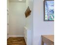 Bright hallway with sleek white storage unit, coat rack, and hardwood floors at 4648 Josephine St, Denver, CO 80216