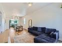 Spacious living room with hardwood floors, blue sofa, and open layout to dining area and kitchen at 4648 Josephine St, Denver, CO 80216