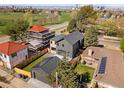 Expansive aerial view of the property featuring a modern home, lush landscaping, and a detached garage with solar panels at 2610 N Monroe St, Denver, CO 80205