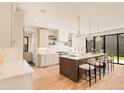 Open kitchen features island seating, modern lighting, stainless appliances, and easy access to the backyard at 2610 N Monroe St, Denver, CO 80205