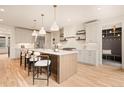Spacious kitchen island with seating, stainless appliances, light cabinets, and open design with access to hall at 2610 N Monroe St, Denver, CO 80205