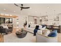 Inviting living room featuring hardwood floors, modern ceiling fan, and open floor plan to the kitchen and dining area at 2610 N Monroe St, Denver, CO 80205