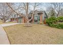 Well-maintained front yard featuring mature trees, lush green grass, and professionally landscaped gardens at 19080 E Low Cir, Aurora, CO 80015
