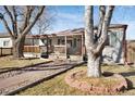 Inviting single-Gathering home featuring a porch, walkway, well-maintained lawn and mature trees at 1927 Kenton St, Aurora, CO 80010