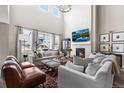 Cozy living room with a fireplace, large windows, comfortable seating, and contemporary decor at 17748 W 95Th Ave, Arvada, CO 80007