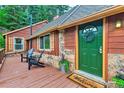 Charming front door with a wreath, a welcome mat, beautiful plants, and wood and stone siding at 7559 S Turkey Creek Rd, Morrison, CO 80465