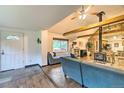 Bright living room featuring wood floors, stone accents, wood beams, and an open layout at 7559 S Turkey Creek Rd, Morrison, CO 80465