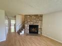 Living room featuring a stone fireplace, hardwood floors, and stairs at 10716 Foxwood Ct, Parker, CO 80138