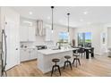 Bright, open kitchen with white cabinets, stainless steel appliances, and an island with bar seating at 5970 S Platte Canyon Dr, Littleton, CO 80123