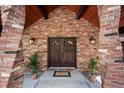Inviting entryway with a beautiful double door, sconce lighting, and brick pillars at 12570 W 60Th Ave, Arvada, CO 80004