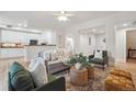 Open living room with hardwood floors, ceiling fan, and seamless flow into the kitchen at 300 Hudson St # 109, Denver, CO 80220