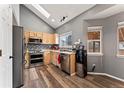 Corner view of kitchen with stainless steel appliances and hardwood floors at 12119 Forest St, Thornton, CO 80241