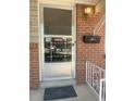 Close-up of the front door with security screen and brick exterior at 451 Lansing St, Aurora, CO 80010