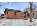 Brick ranch home with a snow-covered yard at 7600 Monaco St, Commerce City, CO 80022