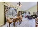 Bright dining room with large windows, decorative curtains, and adjacent living area at 2265 S Depew St, Denver, CO 80227