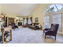 Inviting living room with vaulted ceilings, a cozy fireplace, and abundant natural light from large windows at 2265 S Depew St, Denver, CO 80227