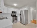 Kitchen featuring white cabinets, stainless steel appliances, white countertop, and neutral flooring, offering ample counter space at 3144 S Wheeling Way # 206, Aurora, CO 80014