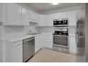 Kitchen featuring all-white cabinetry, modern stainless steel appliances, white countertop, and bright overhead lighting at 3144 S Wheeling Way # 206, Aurora, CO 80014