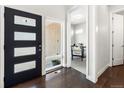 Home entryway with hardwood floors, a modern black door with glass panels, and a view into an office at 6096 W Keene Ave, Denver, CO 80235