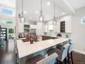 Bright, modern kitchen with a large island, quartz countertop, pendant lighting, and stainless steel appliances at 6096 W Keene Ave, Denver, CO 80235