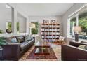 Spacious living room with large bookshelf, stylish furniture, wood floors, and natural light, perfect for relaxing at 531 Americana Rd, Longmont, CO 80504