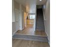 Bright entryway with hardwood floors, carpeted stairs, and a glimpse of the kitchen at 9578 Pearl Cir # 105, Parker, CO 80134