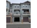 Exterior view of townhome features balconies and attached garages with basketball hoop at 9578 Pearl Cir # 105, Parker, CO 80134