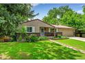 Charming ranch home featuring a well-manicured lawn and beautiful front yard landscaping at 10224 W 68Th Way, Arvada, CO 80004