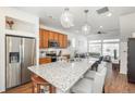 Open kitchen with granite countertop island, stainless appliances and view of the open-concept living area at 4431 N Quatar Ct, Aurora, CO 80019