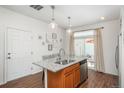 Open kitchen with granite island, stainless dishwasher, and access to outdoor space at 4431 N Quatar Ct, Aurora, CO 80019