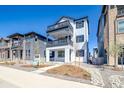 Charming three-story home featuring double balconies, a modern white facade, and professional landscaping at 8509 Orchard City Dr, Littleton, CO 80125