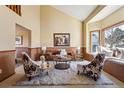 Bright living room featuring high ceilings, a cozy window seat, and stylish decor with a comfortable, inviting ambiance at 7288 S Zephyr Way, Littleton, CO 80128