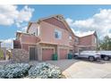 Townhome's exterior featuring attached garages and snow-dusted landscaping on a sunny day at 23505 E Platte Dr # 8D, Aurora, CO 80016
