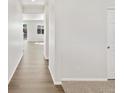 Bright hallway with hardwood floors leading to a sunlit living space at 8850 Sedalia St, Commerce City, CO 80022