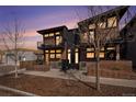 Modern townhouse exterior with brick facade, metal accents, and private balconies at dusk at 2466 S Delaware St # 3, Denver, CO 80223