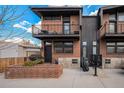 Modern townhouse exterior with brick facade, metal accents, and private balconies at 2466 S Delaware St # 3, Denver, CO 80223