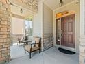 Inviting front porch with cozy seating, stone pillars, and a welcoming entrance at 13645 Osage Ct, Broomfield, CO 80023