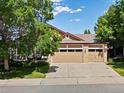 Charming home exterior featuring a three car garage and beautiful landscaping on sunny day at 885 Sage Sparrow Cir, Highlands Ranch, CO 80129