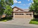 Charming home featuring a three car garage, brick accents, and mature landscaping at 885 Sage Sparrow Cir, Highlands Ranch, CO 80129