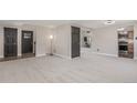 Spacious living room with neutral carpet, gray doors and trim, and access to the kitchen at 7367 Coors St, Arvada, CO 80005