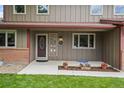 Inviting front entrance with decorative glass door, flanked by colorful flowerpots and lush green lawn at 7409 Mount Meeker Rd, Longmont, CO 80503